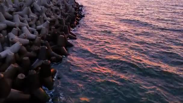 파도는 해안의 콘크리트 테트라포드 브레이크워터에 부서집니다 파도에서 일몰에 Wladyslavovo 항구에서 — 비디오