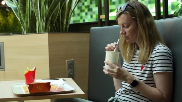 マクドナルドのレストランで朝食を食べる女性 マッカフェでハンバーガーやフライドポテトを食べる女性 ファーストフード栄養 ヴロツワフ ポーランド 2023 — ストック動画