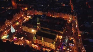 Wroclaw eski kasaba meydanında Noel süsü ve aydınlatma ile insansız hava aracı uçuşu. Wroclaw 'daki Noel panayırında yürüyen turistler