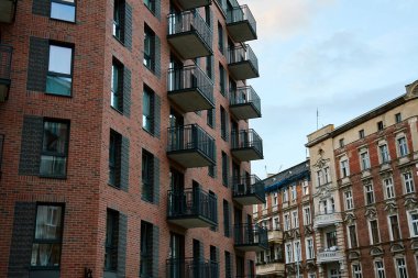 Madern malikanesinin ön cephesinde eski bir bina var. Modern şehir mimarisi. Kırmızı tuğlalardan yapılmış bir apartman.