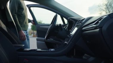 Erkek sürücünün kapısı açık ve arabada otururken yan görüntüsü. Sürüş için hazırlanan adam