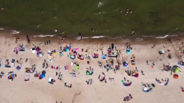 Wladyslawo 'daki kalabalık kumsal manzaralı deniz manzarası. Polonya 'da yüzen insanlarla dolu Baltık deniz kıyıları. Yaz mevsiminde tatil köyü