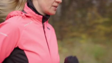 Yolda koşan bir kadın. Stadyumda koşan bayan koşucu. Sonbahar günü açık havada aktif spor egzersizleri. Sağlıklı yaşam tarzı