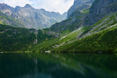 Yaz günü güzel göl kenarındaki dağların muhteşem manzarası. Polonya 'daki Tatra Ulusal Parkı. Beş Göl Vadisi 'ndeki Morskie Oko ya da Sea Eye Gölü' nün panoramik manzarası