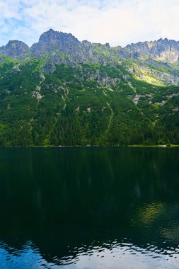 Yaz günü güzel göl kenarındaki dağların muhteşem manzarası. Polonya 'daki Tatra Ulusal Parkı. Beş Göl Vadisi 'ndeki Morskie Oko ya da Sea Eye Gölü' nün panoramik manzarası