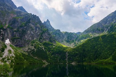 Yaz günü güzel göl kenarındaki dağların muhteşem manzarası. Polonya 'daki Tatra Ulusal Parkı. Beş Göl Vadisi 'ndeki Morskie Oko ya da Sea Eye Gölü' nün panoramik manzarası