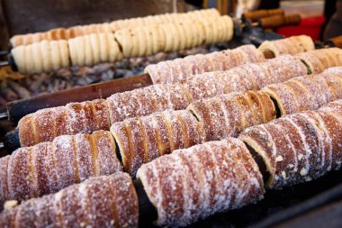 Prag 'da trdelnik pişirme süreci, şekerli ızgara hamur sarma, Prag' da geleneksel Çek sıcak tatlısı, sokak fırını