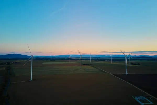 Aerial view of wind turbine in countryside area, Wind power plants in agricultural landscape at sunset, Green energy from renewable sources concept