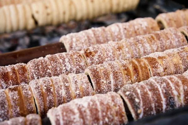 Prag 'da trdelnik pişirme süreci, şekerli ızgara hamur sarma, Prag' da geleneksel Çek sıcak tatlısı, sokak fırını