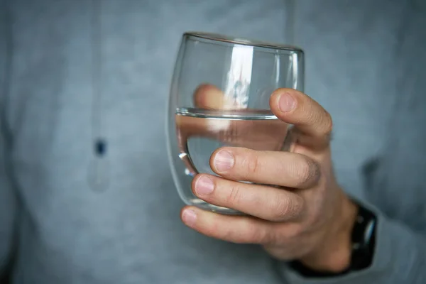Man drinks water, Close-up shot of man holding glass of fresh water, Quenching thirst, Lifestyle healthcare concept