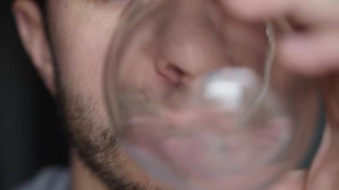 Adam su içiyor, yakın plan sakallı adam temiz su içiyor, susuzluğu gideriyor, yaşam tarzı sağlık sigortası kavramı.