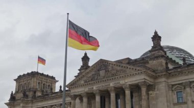 Almanya 'nın ulusal bayrağı Berlin' deki Reichstag binasında rüzgarda dalgalanıyor.