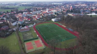 Koşu bandı ve futbol sahası olan stadyumun havadan görünüşü. Çocuklar parkın yakınındaki küçük bir taşra kasabasında sahada futbol oynarlar.