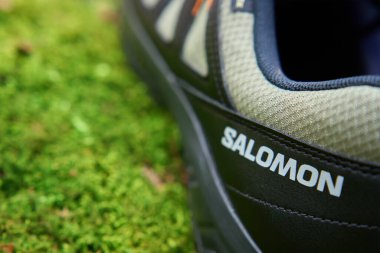 Salomon X Braze GTX yürüyüş botları ve canlı yeşil yosun üzerinde Gore-Tex zarları. Doğada gezinti ayakkabıları. Keşif ve açık hava aktiviteleri kavramı. Wroclaw, Polonya - 2 Mart 2024