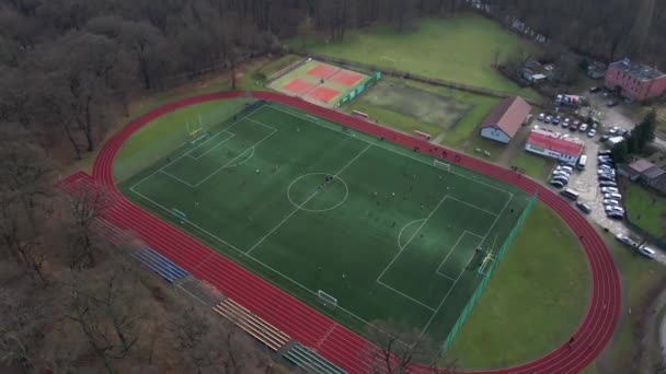 城市里有跑步机和足球场的体育场的空中景观 孩子们在公园附近的一个小城镇的田里踢足球 — 图库视频影像