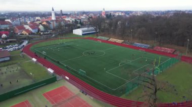 Koşu bandı ve futbol sahası olan stadyumun havadan görünüşü. Çocuklar parkın yakınındaki küçük bir taşra kasabasında sahada futbol oynarlar.