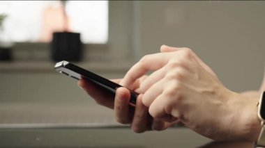 Ekranda sosyal medya görüntüsü olan akıllı telefonu rastgele kullanan kişi dijital içerikli bir müdahale öneriyor. Evde cep telefonu kullanan bir kadın