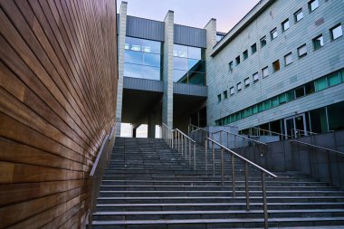 Şehirde kamusal alan. Merdivenleri ve rayları olan modern bir bina.