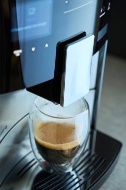 Sabah taze espresso. Kahve makinesi, cam bardakta taze demlenmiş kahve. Mutfak aletleri.