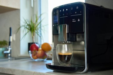Sabah taze espresso. Mutfaktaki kahve makinesi, kapat. Cam bardakta yeni demlenmiş kahve makinesi. Mutfak aletleri.