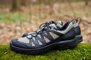 Canlı yeşil yosun üzerinde sağlam yürüyüş botları. Doğada gezinti ayakkabıları. Keşif ve açık hava aktiviteleri kavramı