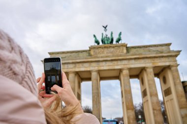 Berlin 'deki Brandenburg Kapısı' nın kadın turist fotoğrafı. Almanya 'nın tarihi mimari simgesi. Turistler için turistik yerler