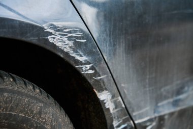 Çizik, çizik kapı ve arka çamurluğu olan bir araba. Şehir caddesinde hasarlı araç