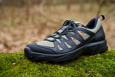 Canlı yeşil yosun üzerinde sağlam yürüyüş botları. Doğada gezinti ayakkabıları. Keşif ve açık hava aktiviteleri kavramı