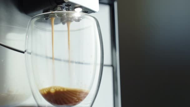 朝日光を浴びた透明なガラスでコーヒーを醸造する自動コーヒーマシン カップで新鮮なエスプレッソショットと蒸気が上がりました 毎日の朝のルーチン — ストック動画