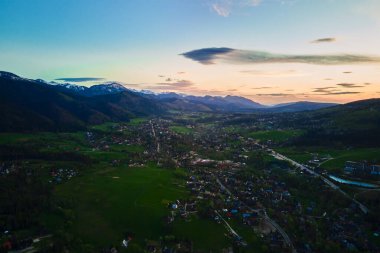 Gün batımında Tatra dağları ve Zakopane kasabasının hava manzarası. Köyün yakınındaki dağ sıraları ve yeşil vadilerle panoramik bir manzara. Giewont, Polonya 'ya Bakış