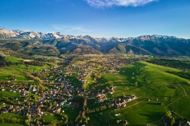 Gün batımında Tatra dağları ve Zakopane kasabasının hava manzarası. Köyün yakınındaki dağ sıraları ve yeşil vadilerle panoramik bir manzara. Giewont, Polonya 'ya Bakış