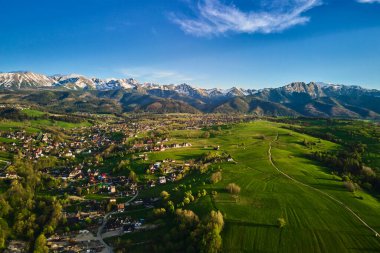 Gün batımında Tatra dağları ve Zakopane kasabasının hava manzarası. Köyün yakınındaki dağ sıraları ve yeşil vadilerle panoramik bir manzara. Giewont, Polonya 'ya Bakış