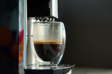 Sabah taze espresso. Kahve makinesi, cam bardakta taze demlenmiş kahve. Mutfak aletleri.