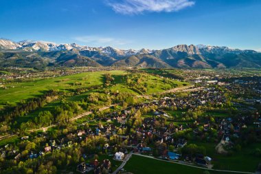 Gün batımında Tatra dağları ve Zakopane kasabasının hava manzarası. Köyün yakınındaki dağ sıraları ve yeşil vadilerle panoramik bir manzara. Giewont, Polonya 'ya Bakış