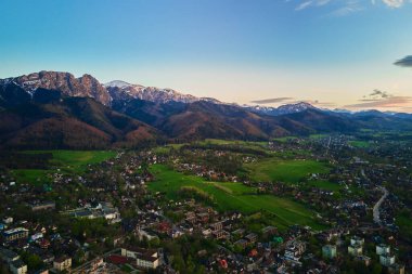 Gün batımında Tatra dağları ve Zakopane kasabasının hava manzarası. Köyün yakınındaki dağ sıraları ve yeşil vadilerle panoramik bir manzara. Giewont, Polonya 'ya Bakış