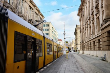 Sarı tramvay Berlin, Almanya ve Televizyon Kulesi 'nde caddeye park edilmiştir. Toplu taşıma. Berlin, Almanya - 24 Ocak 2024