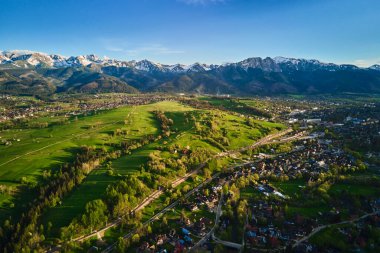 Gün batımında Tatra dağları ve Zakopane kasabasının hava manzarası. Köyün yakınındaki dağ sıraları ve yeşil vadilerle panoramik bir manzara. Giewont, Polonya 'ya Bakış