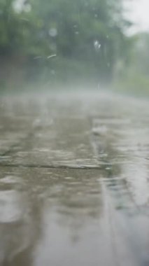 Kaldırıma düşen yağmur damlalarının yakın çekimi. Yağmurlu bir gün. Şiddetli yağmurlu kötü hava