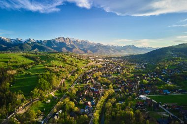 Gün batımında Tatra dağları ve Zakopane kasabasının hava manzarası. Köyün yakınındaki dağ sıraları ve yeşil vadilerle panoramik bir manzara. Giewont, Polonya 'ya Bakış