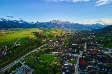 Gün batımında Tatra dağları ve Zakopane kasabasının hava manzarası. Köyün yakınındaki dağ sıraları ve yeşil vadilerle panoramik bir manzara. Giewont, Polonya 'ya Bakış