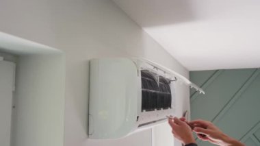 Klima bakımı. Erkek teknisyen oturma odasındaki iklim sistemini tamir ediyor. İnsan saç kreminin filtrelerini temizliyor.