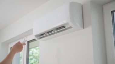 Modern apartmanın beyaz duvarına klima monte edilmiş. Oturma odasında rahat sıcaklık için soğutma sistemi