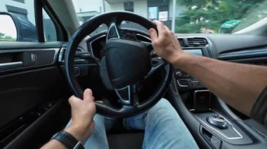 Erkek sürücü arabayı evin avlusundaki otoparka park ediyor, ilk bakışta. Adam arabayı sürüyor, geri geri gidiyor.