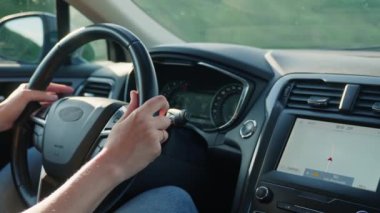 Direksiyondaki kadın sürücünün yakın görüntüsü. Gün batımında araba süren kadın. Yollarda ilerleyen modern aracın iç görünümü