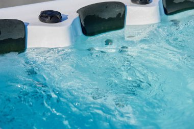 Jakuzide kafalık ile kaynayan suyu yakından çek. Jakuzide rahatlatıcı ve rahatlatıcı spa deneyimi için mavi su