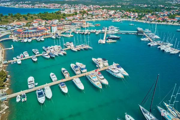 Hırvatistan 'ın Rogoznica kentindeki Frapa marinasına güneşli yaz gününde lüks yatlar ve yelkenliler yanaşıyor. Adriyatik Denizi, Dalmaçya bölgesinde yaz tatili için turistik bir şehir. Yaz tatili kavramı