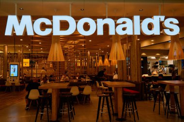 McDonalds 'ın modern ahşap dekorlu restoranı. Modern fast food restoranının içinde self servis büfeleri var. Kopenhag, Danimarka - 26 Haziran 2024