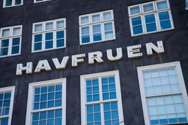 Üzerinde HAVFRUEN yazan eski tarihi bir bina. Kopenhag 'daki Nyhavn Limanı. Danimarka 'nın ünlü turistik mekanı. Kopenhag, Danimarka - 26 Haziran 2024