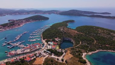 Sahil kasabası ve yatları olan deniz manzarası. Adriyatik Denizi 'ndeki adalar arasında yaz tatili için turistik şehir. Hırvatistan 'ın Rogoznica kentinde marina Frapa ve Ejderha Gözü gölünün panoramik manzarası