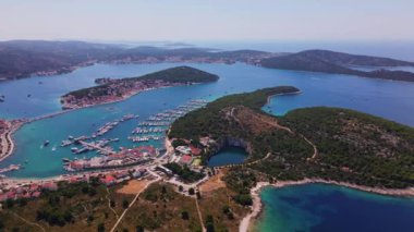 Sahil kasabası ve yatları olan deniz manzarası. Adriyatik Denizi 'ndeki adalar arasında yaz tatili için turistik şehir. Hırvatistan 'ın Rogoznica kentinde marina Frapa ve Ejderha Gözü gölünün panoramik manzarası